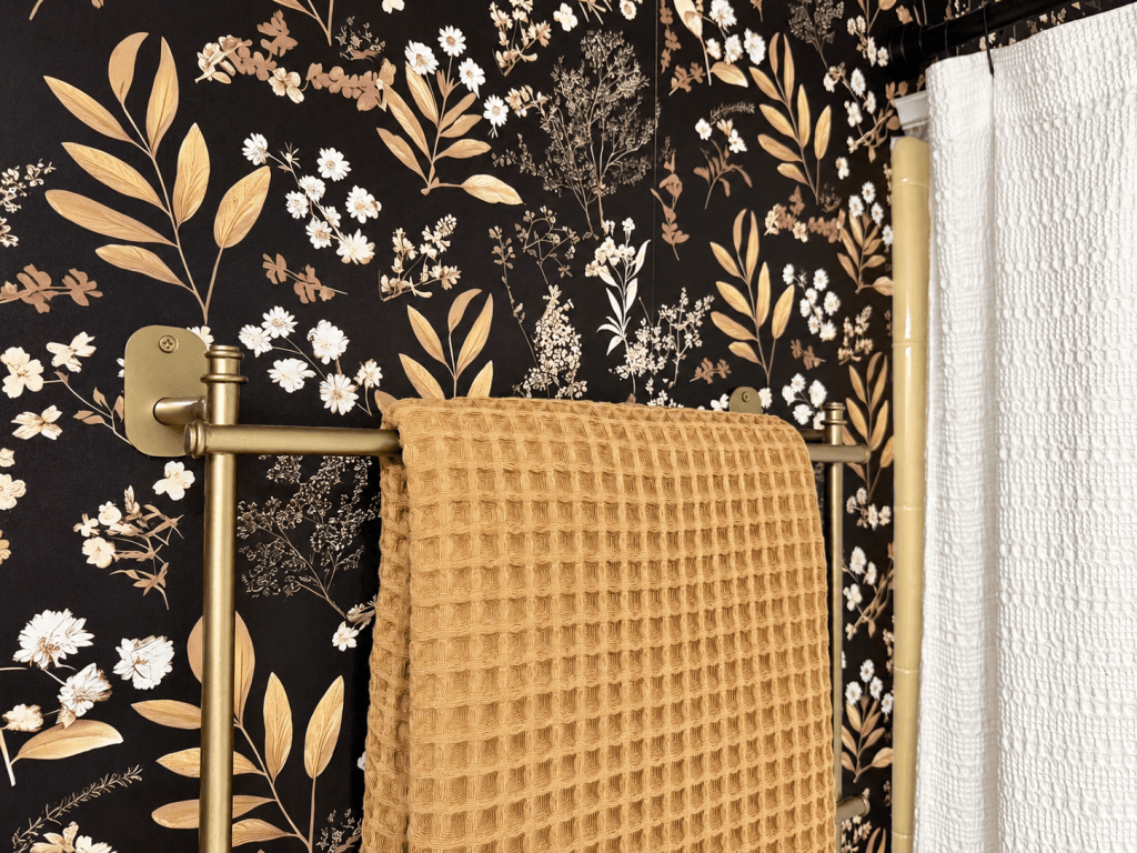 Amazon dark floral wallpaper with brass towel holder and 1970's yellow tile